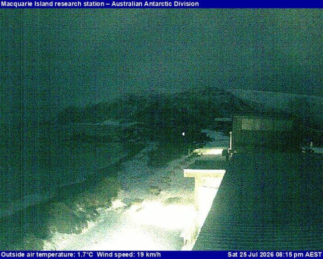 A view of the Macquarie Island research station with the ocean and mountains prominently in the view.