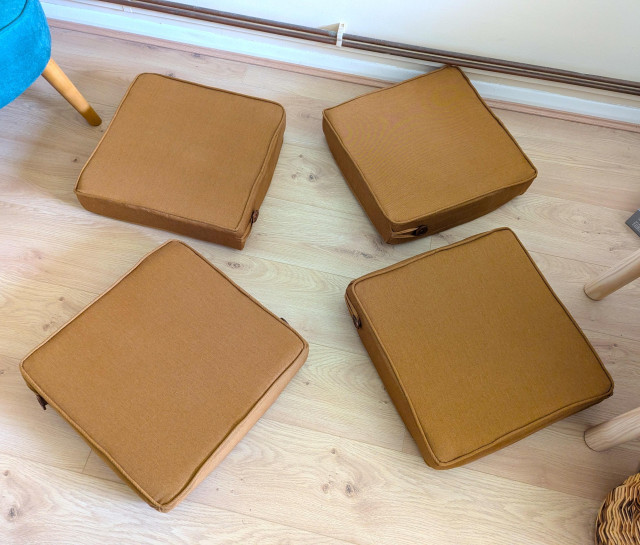 The same four cushions scattered individually on the floor.