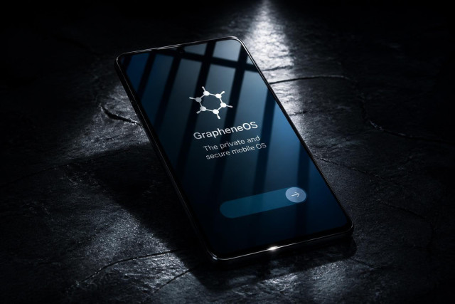 Image of a mobile phone (smartphone) running Graphene OS, an open source privacy-focused operating system. The device is placed in a cold prison cell because the owner used a duress password during an active investigation.