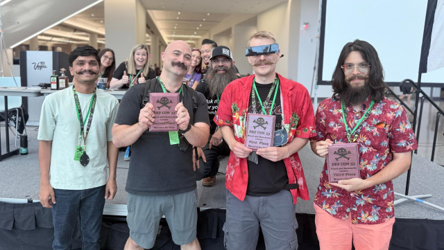 Four people proudly display their awards at the DEF CON Beard and Mustache Contest.