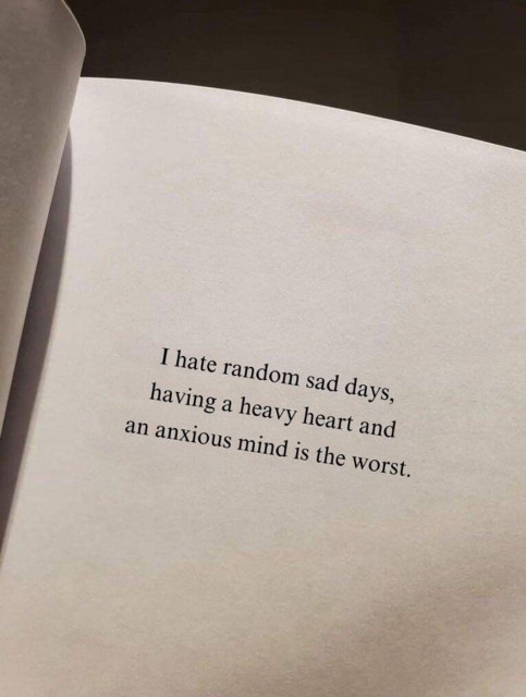 The image displays an open book with typeset text reading, "I hate random sad days, having a heavy heart and an anxious mind is the worst."