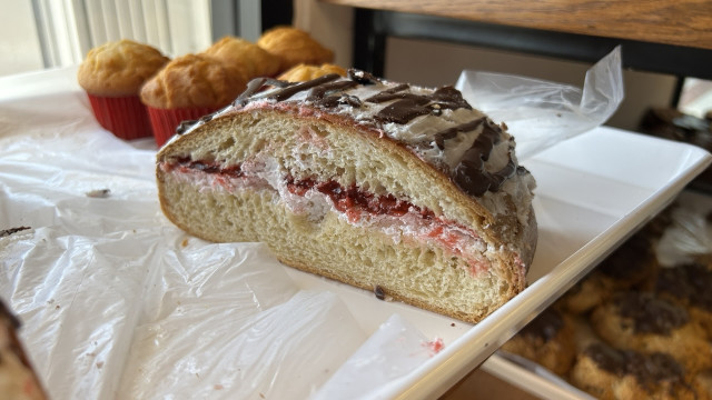 A pastry with glaze and chocolate on top and strawberries and cream inside. So yummy, my favorite!