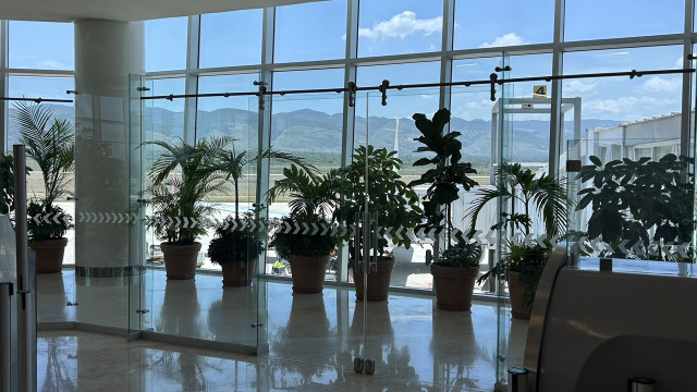 View at the boarding gate at Chiapas Airport shows mountains in the distance through a wall of windows