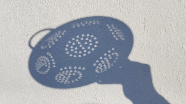 Shadow cast by a colander, all the circles are little crescents 