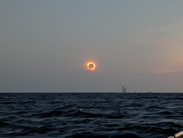 A photo of the total solar eclipse August 2026, taken from a boat off the south coast of Mallorca. A number of other boats are visible in the middle distance.
