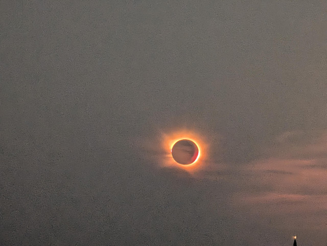 A closer shot of the total eclipse. There is some light haze in the sky, dramatically setting off the ring of fire from the eclipse.