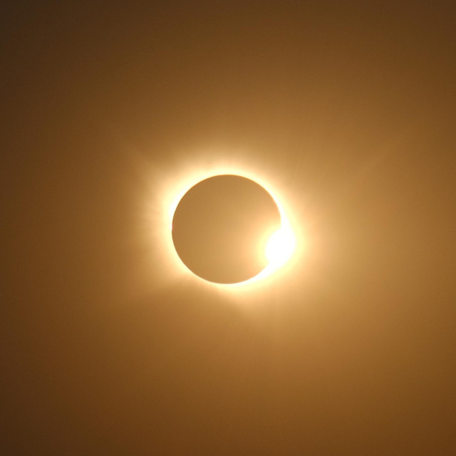 Éclipse totale de soleil. Le coin inférieur droit du soleil apparaît derrière la Lune 