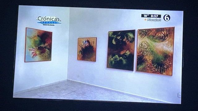 Paintings hanging in a corner of a white walled gallery 