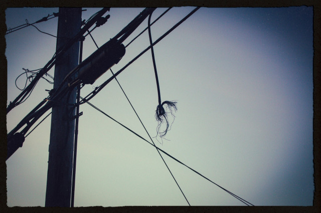 dusk photo of a utility pole with a dangling power line that's been frayed