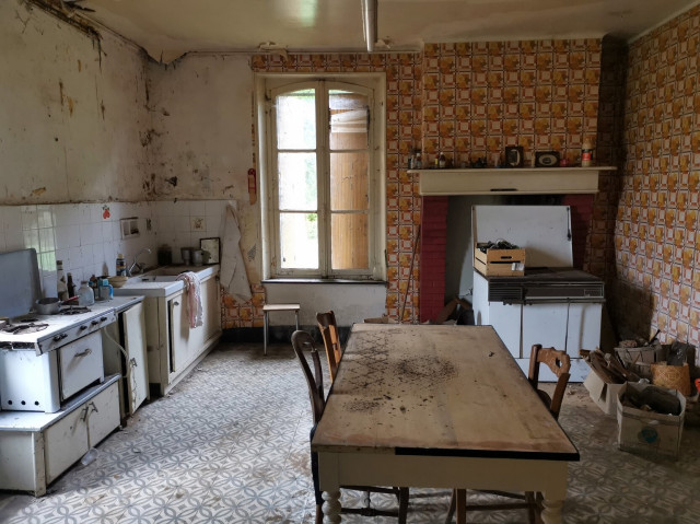 Old French kitchen wit wooden table, and wood burning stove. 